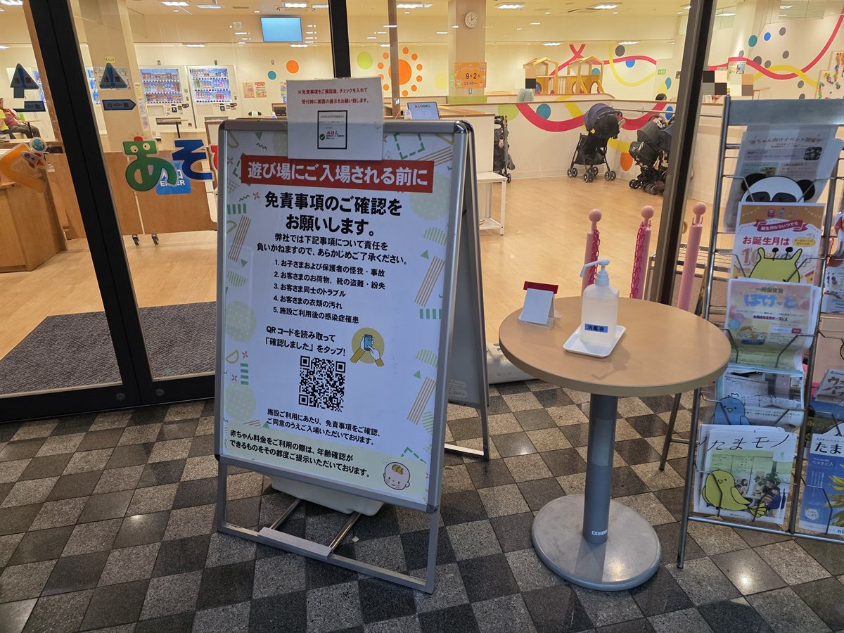 入場前の免責事項確認QRコードの案内板。周囲の人物の顔部分にはモザイク加工済み