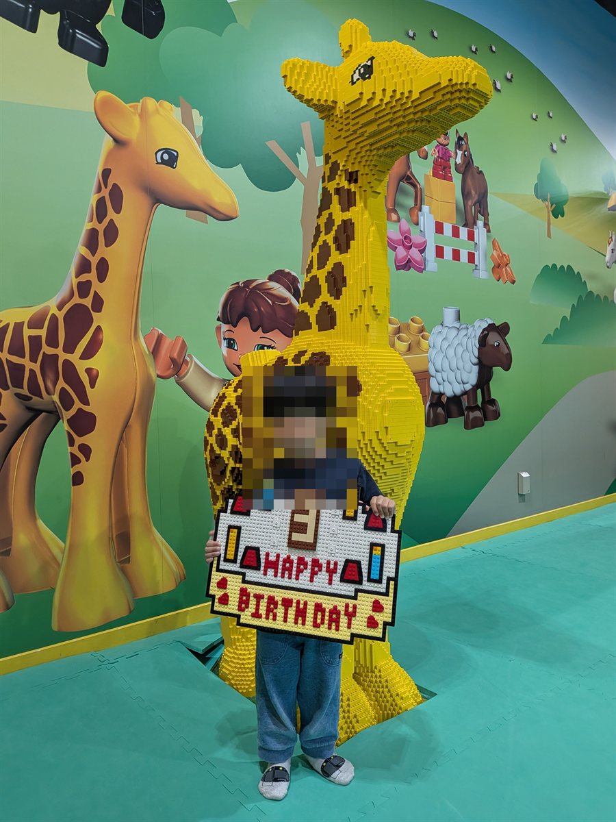 レゴブロックで作られたバースデープレートを持つ子ども